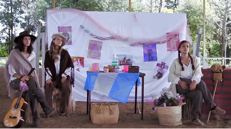 Escenografía de Neo-Criollo montada en el campo, con tres personajes vestidos de gauchos