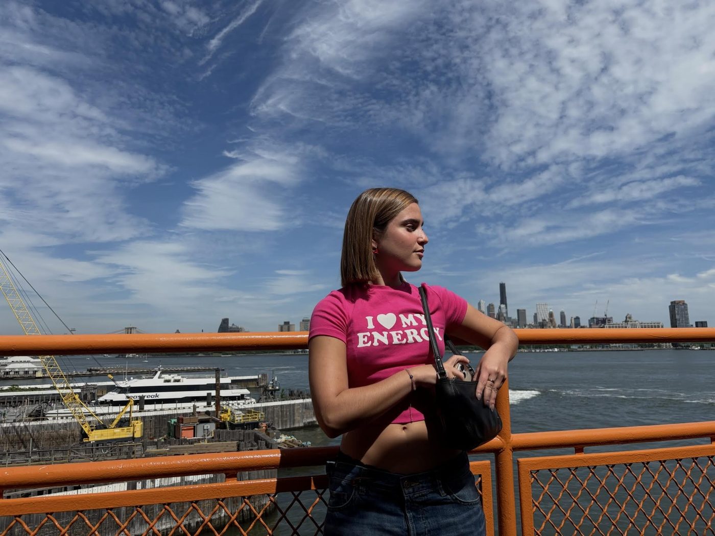 Milagros con remera rosa en un barco frente a la ciudad