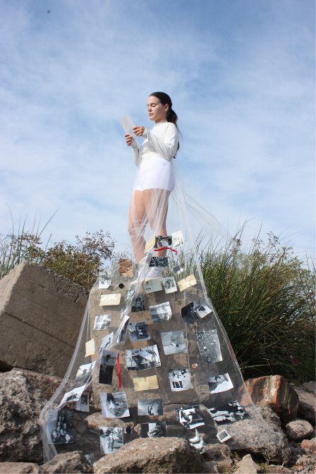 Modelo de pie sobre una roca con la capa de fotos desplegada